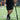 Player holding black training bat with game-like barrel shape, pairs with foam baseballs on turf field