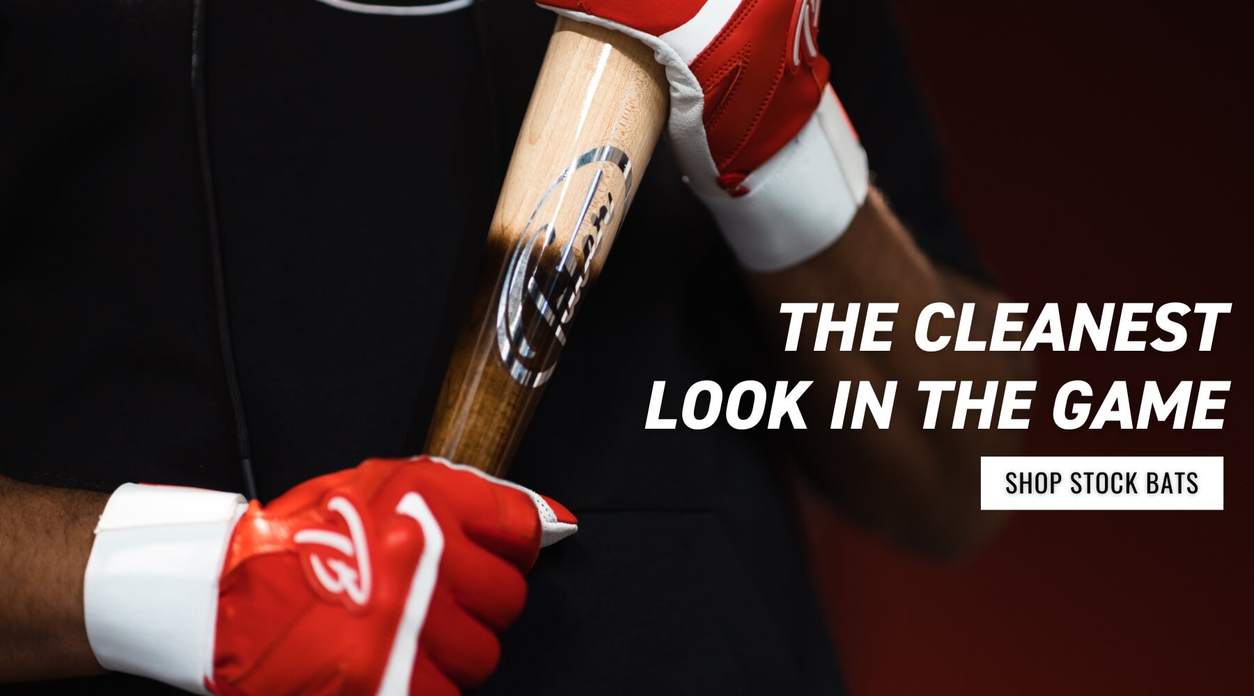 A close-up of a baseball player holding a pine tar bat with a clear focus on the Tater logo. The player wears red and white batting gloves.