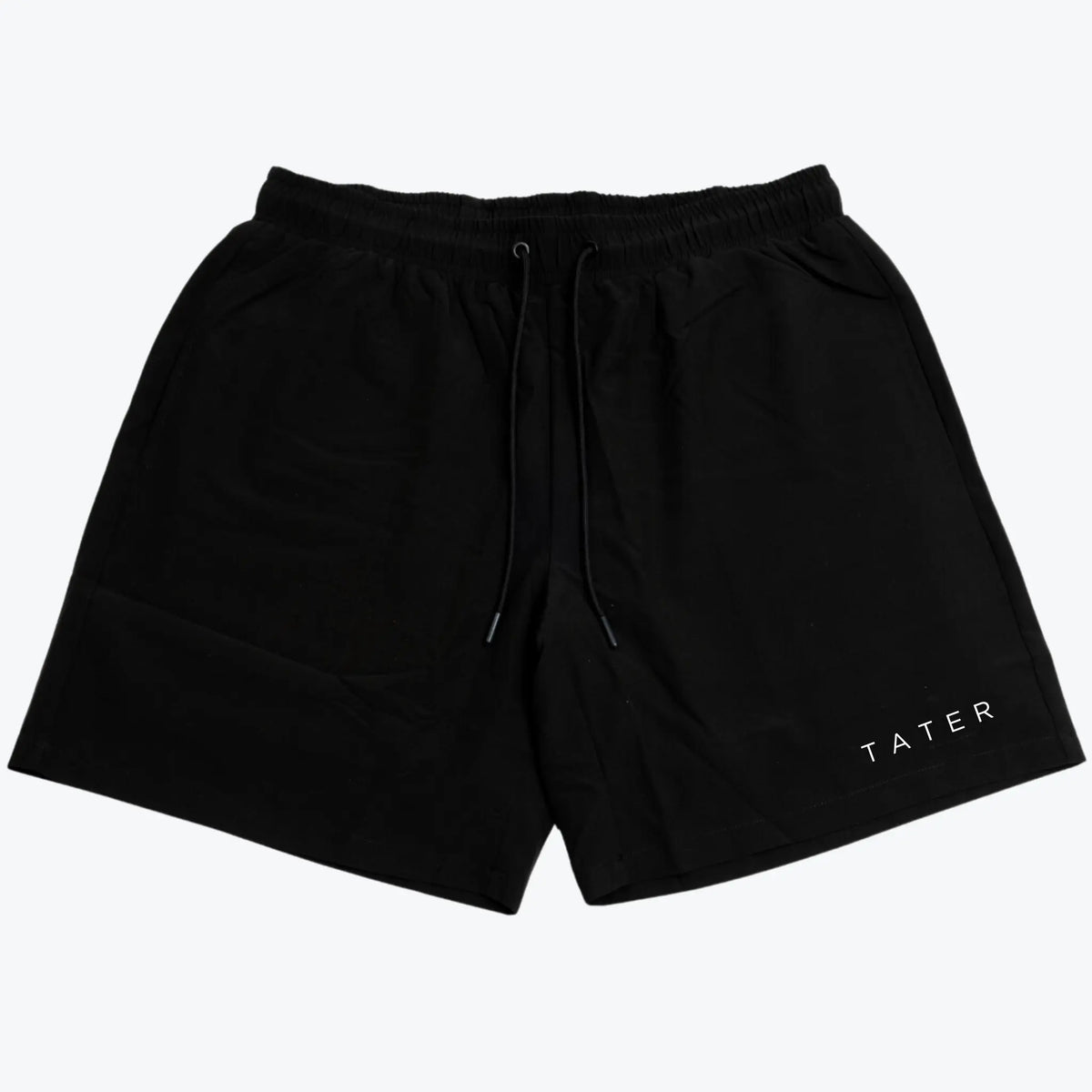 The image displays a pair of black athletic workout shorts that feature a white &quot;TATER&quot; logo on the left leg. These shorts are likely designed for comfort and performance, suitable for baseball practice or general athletic activities. The shorts seem to have a drawstring for adjustable fit and might be compression lined, offering additional support and mobility for athletes. The black color is classic, making them versatile for pairing with other athletic wear.