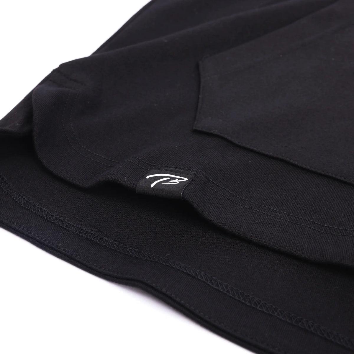 Close-up of a black FUNDAMENTALS fitted short-sleeve hoodie with a subtle white &#39;TB&#39; logo from Tater Baseball, highlighting the brand&#39;s minimalist design.