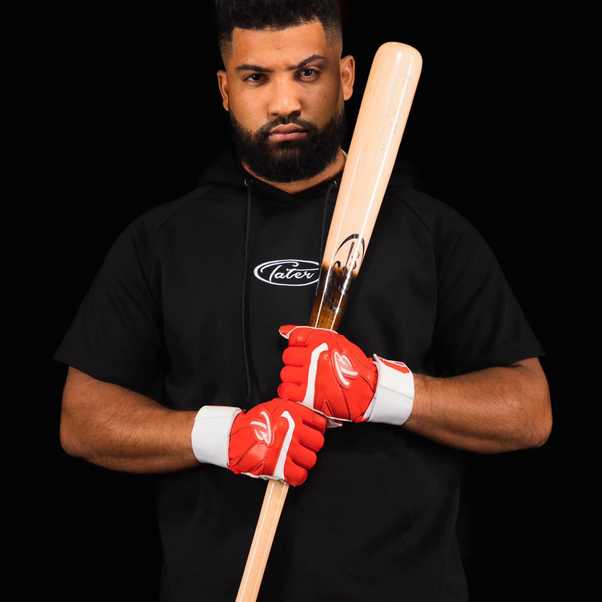 A high-quality wooden baseball bat with a dark brown pine tar grip, showcasing the Tater Baseball logo near the handle.This image features two Tater X12 Pro Maple baseball bats in a crossed position against a clear background. The top bat is displayed with the handle towards us, showing off the smooth pine tar finish, while the bottom bat presents the barrel with the brand's logo clearly visible, suggesting a bat well-suited for high school players due to its balance and craftsmanship.