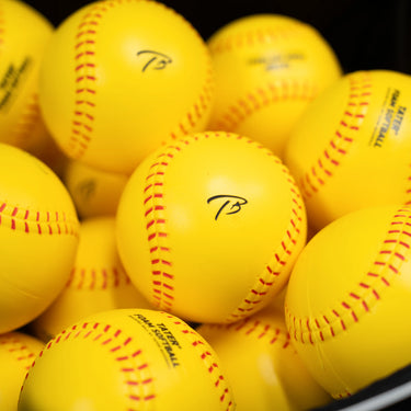 Bucket of yellow Tater foam softballs for pitching machine practice